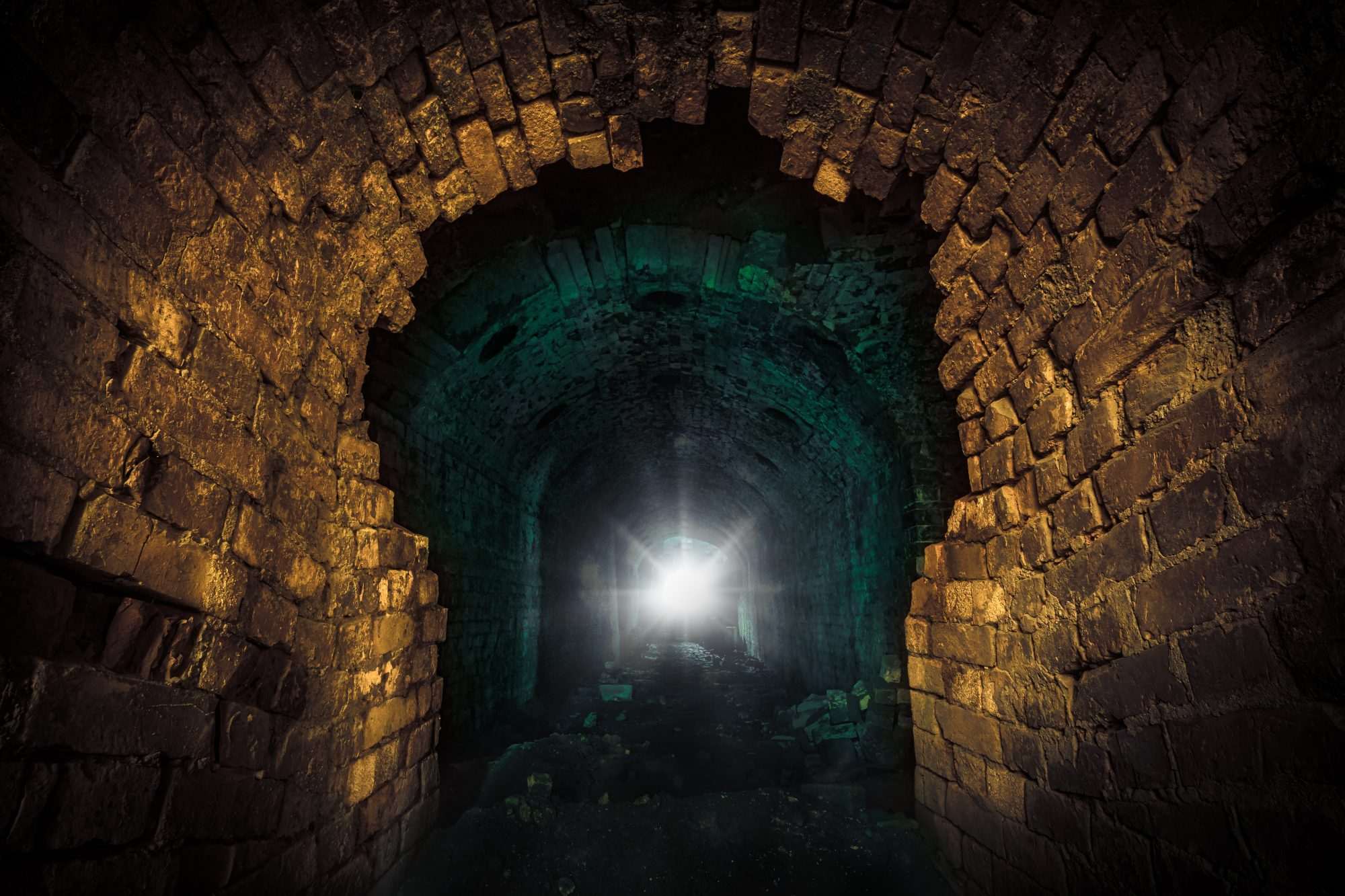 Fotobehang Donkere Stenen Tunnel met Lichtpunt - Afbeelding 2